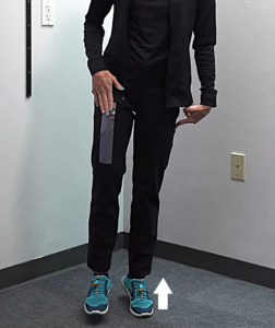 Image of Tara Tobias demonstrating a vaulting gait, standing on the toes of her left foot while swinging her right foot forward.